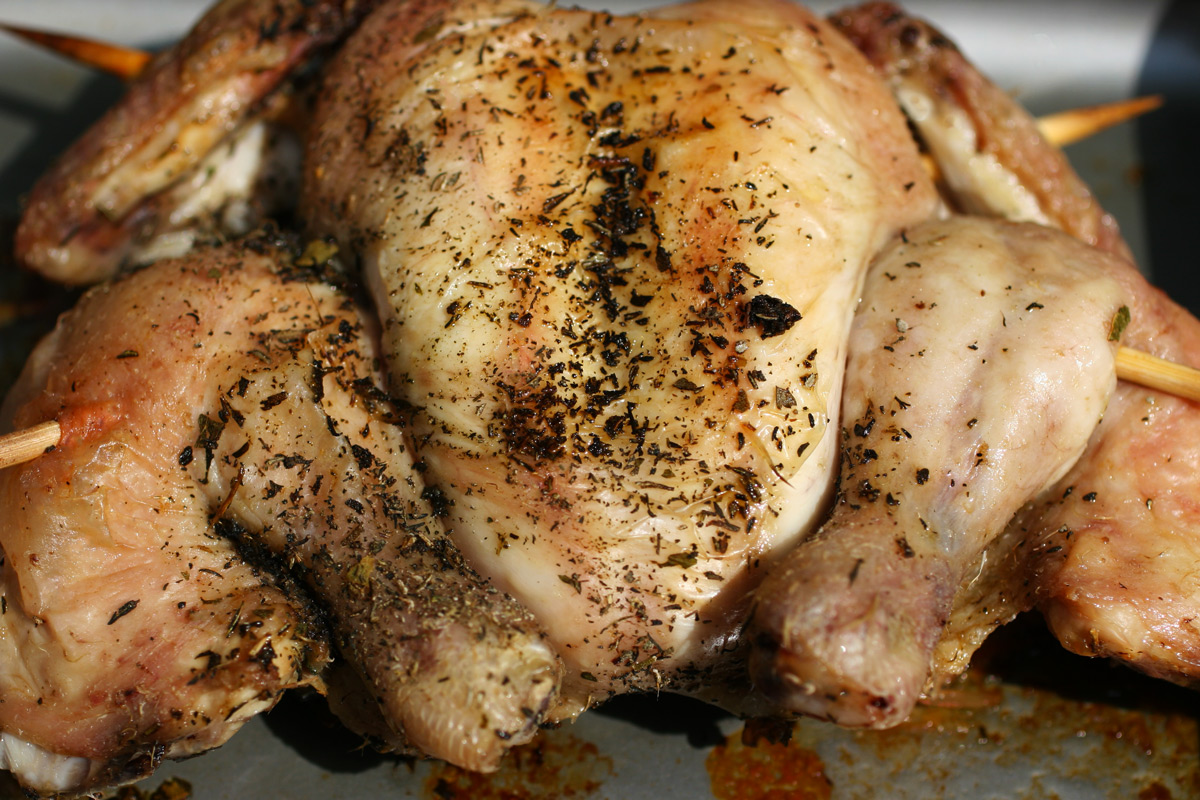 A grilled chicken with herb butter fresh from the oven.