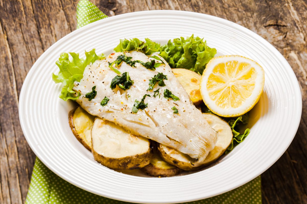 Lemon and herb baked cod in a serving plate.