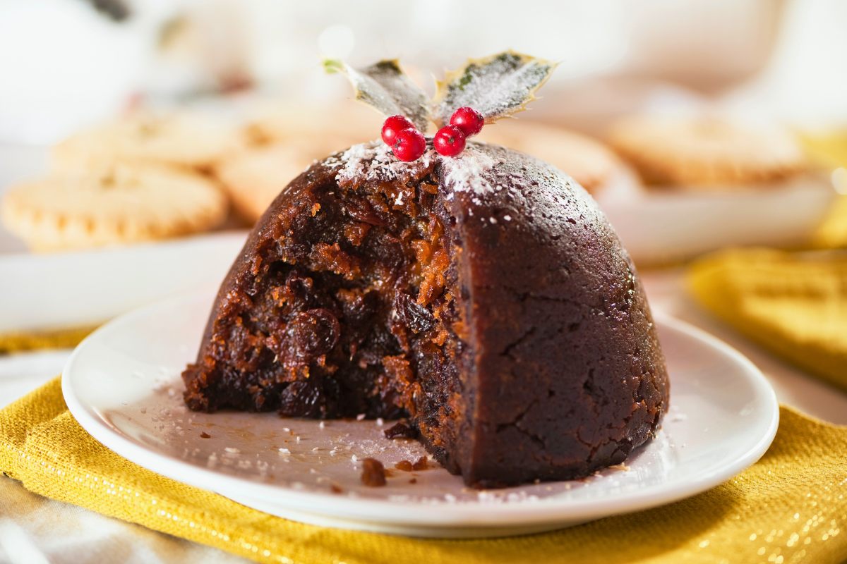 Christmas pudding with a section cut, showing the fruity interior.