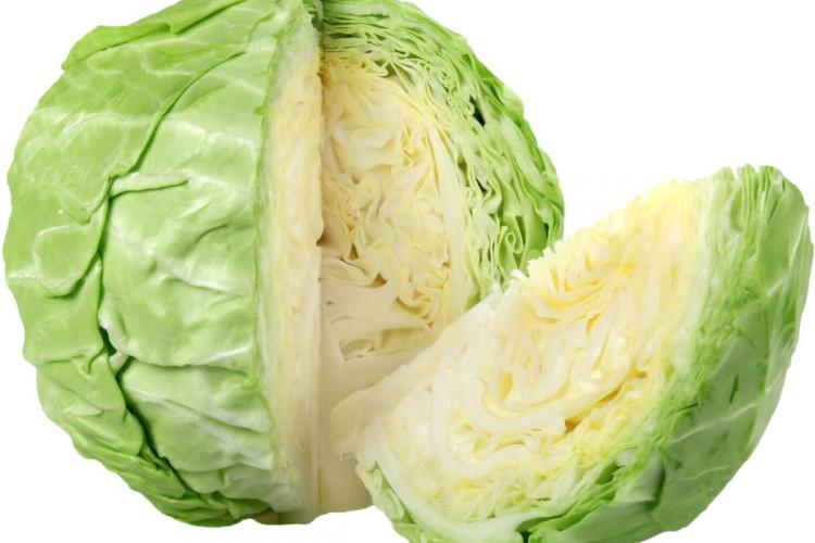 An isolated round cabbage with a wedge cut out.
