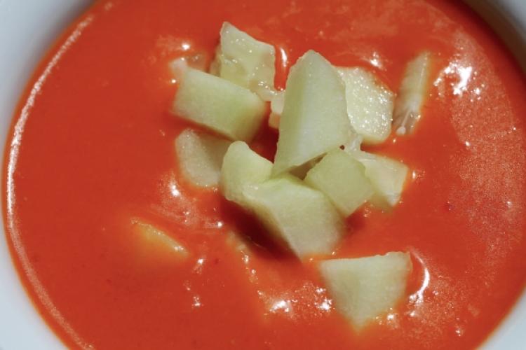 Andalusian gazpacho, a chilled tomato soup, with cucumber garnish.