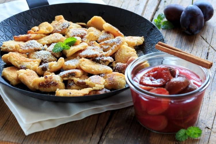 Kaiserschmarrn with plum compote in a pan.