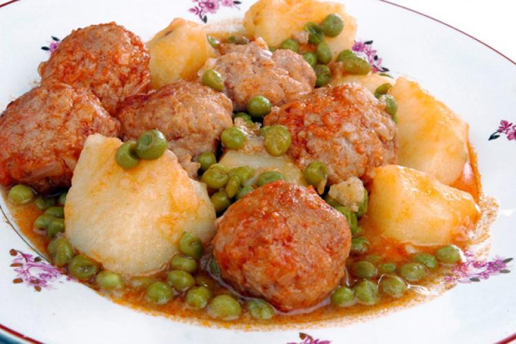 Meatballs stewed with peas and potatoes.