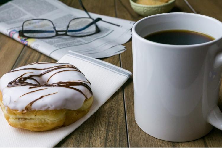 A cup of coffee and a doughnut.