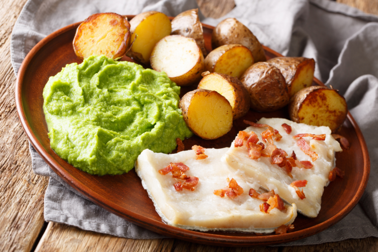 Lutefisk served with pea pure, potatoes and bacon.