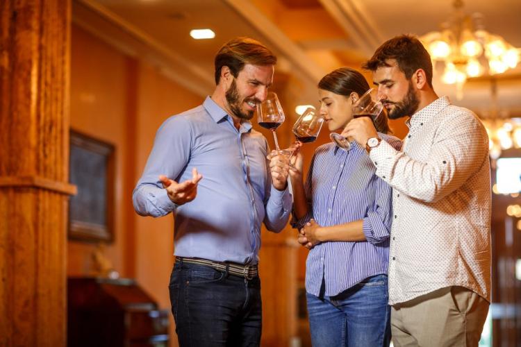 A group of three friends tasting wine.
