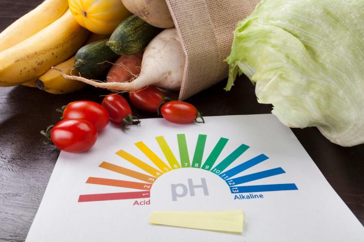 A pH scale awith some of acidic foods spilling out of a bag behind.