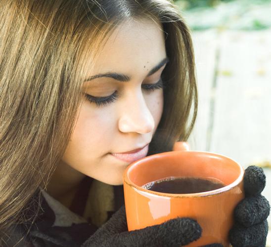 A woman with a cup of black coffee.