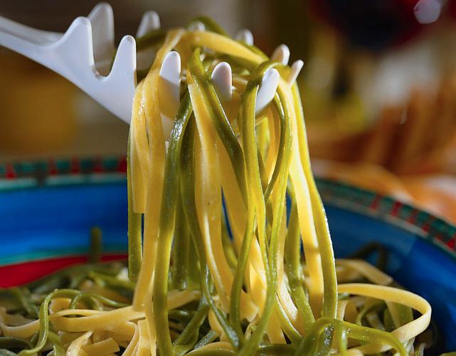 Pasta holder draining cooked tagliatelle our of the pan.