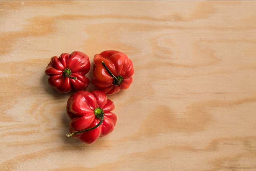 Three fresh habanero chiles on wood.