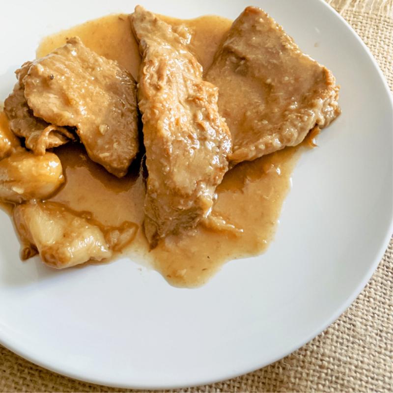 A plate of pork tenderloin in a wine sauce.