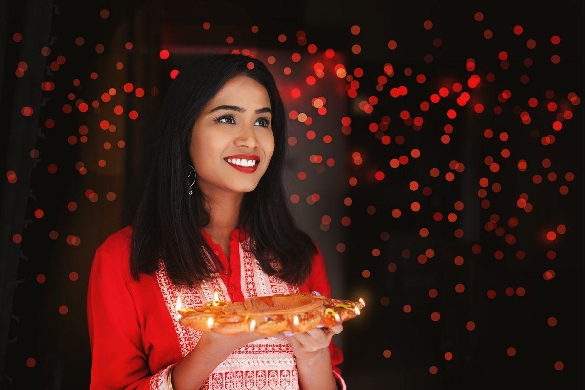 Indian woman holidng diya tali for Diwali.