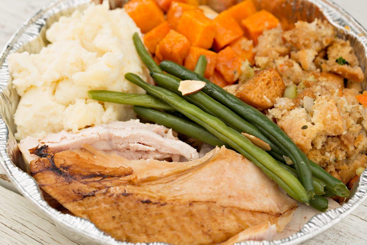 Turkey dinner leftovers packed in a foil tray.