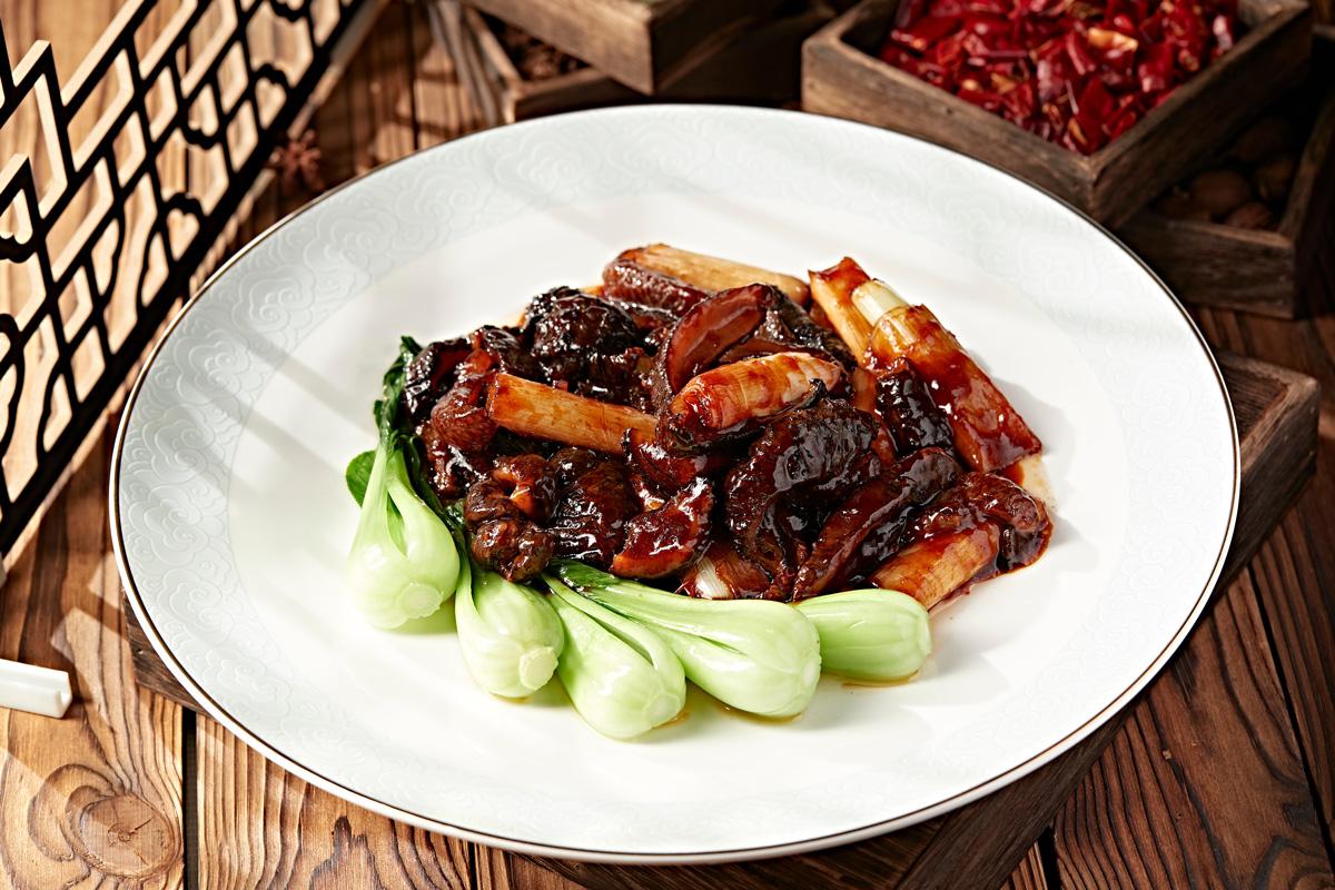 Classic traditional Shandong cuisine, scallion fried sea cucumber with blanches bok choi.