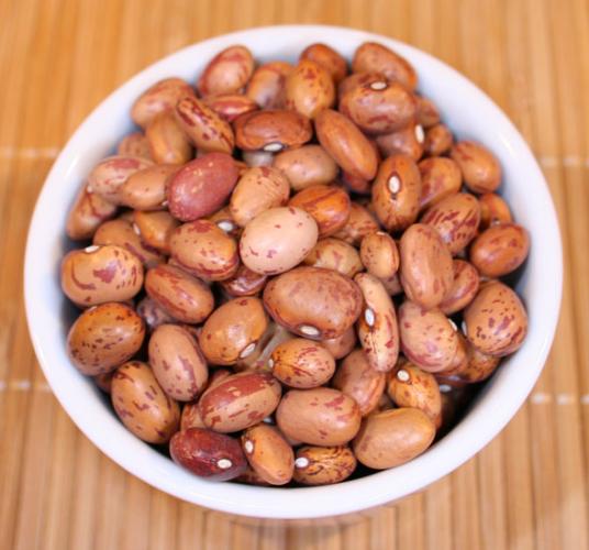 Pinto beans in a white container.