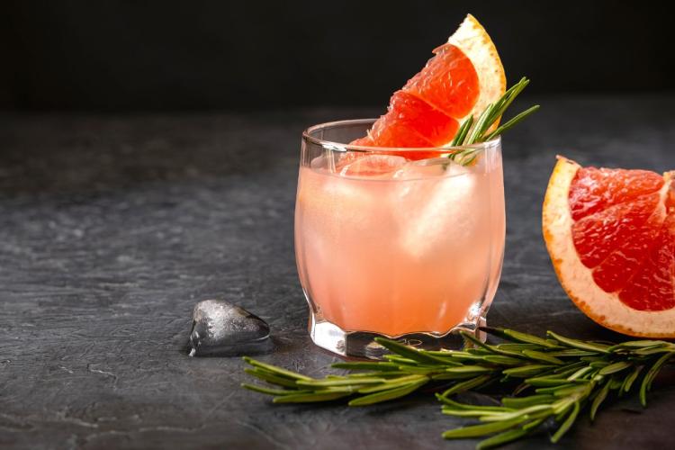 Pink grapefruit spritz with slice of pink grapefruit and rosemary.