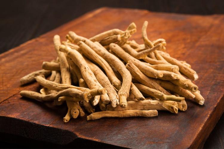 Pile of dried ashwagandha roots on a wooden board.