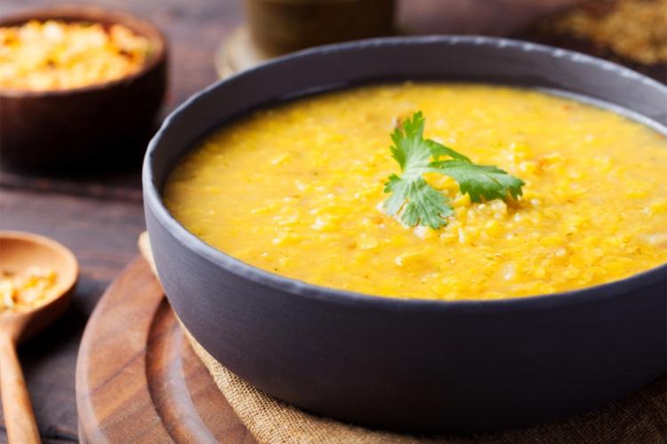 A bowl of smooth red lentil soup with cumin and preserved lemon.