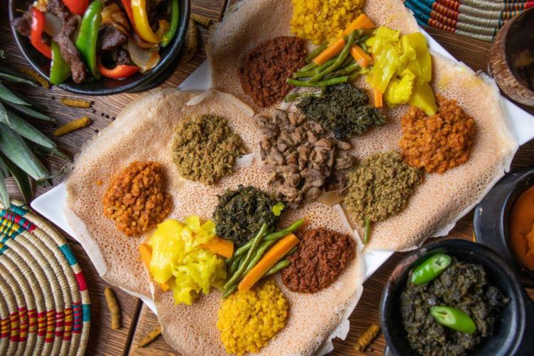 Ethiopian injera platter served with assorted lentil stews, meat and vegetables.
