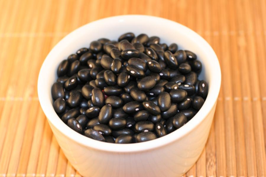 Black turtle beans in a white container.