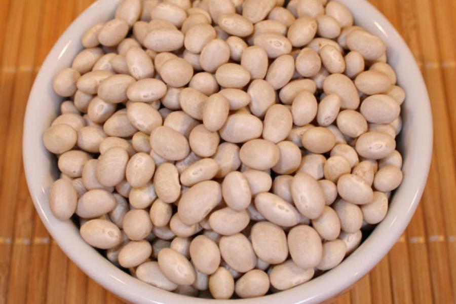 Dry haricot beans in a white container.