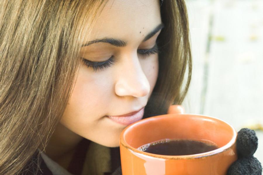 A woman with a cup of black coffee.