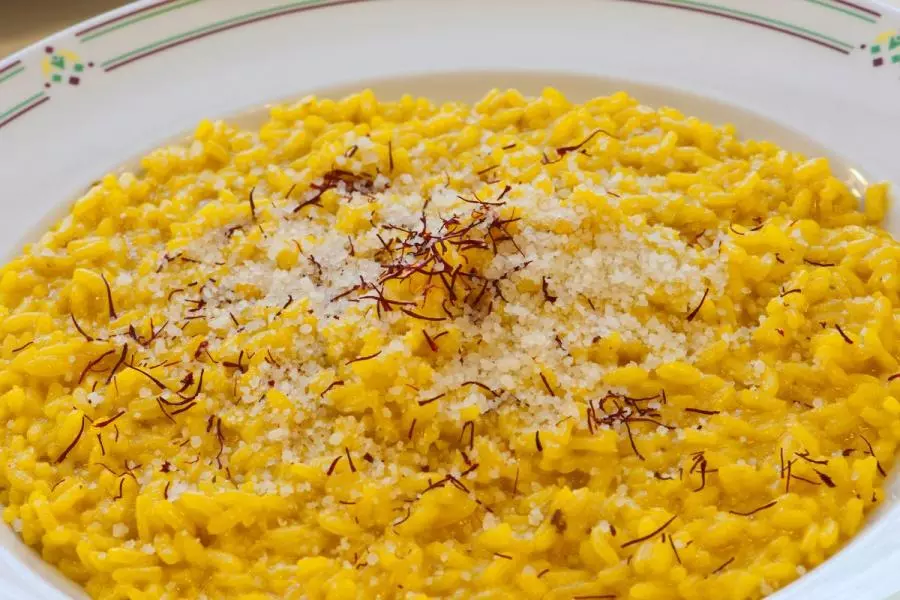 Risotto alla Milanese topped with grated cheese and saffron threads