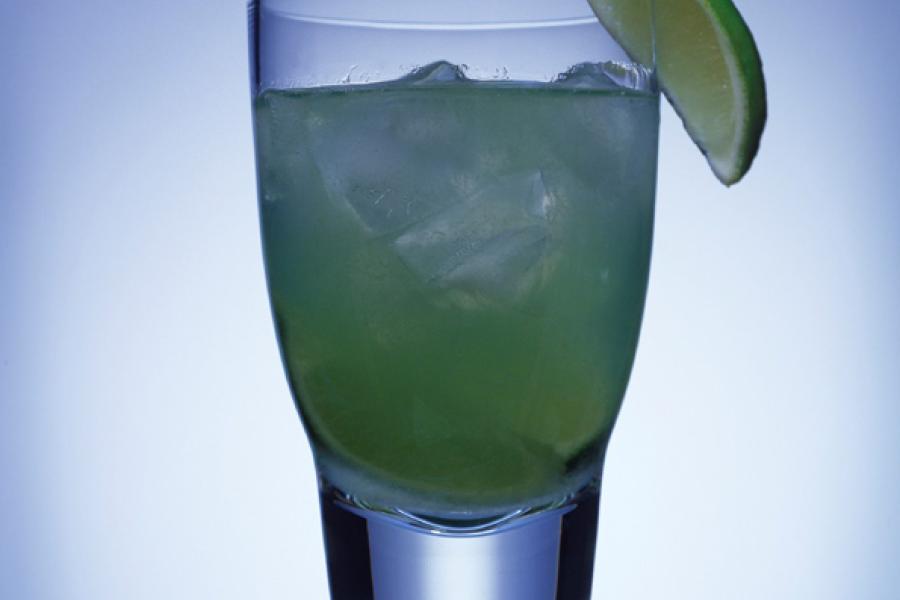 A glass with the drink surfer's paradise, a refreshing combination with lime.