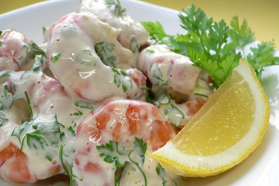 A plate of shrimp salad decorated with chervil.