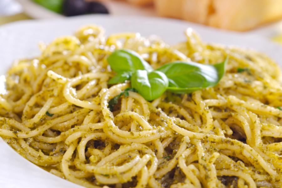 A plate of spaghetti with pesto sauce