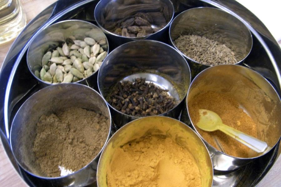 Typical Indian spice box with severarl spices in their containers.