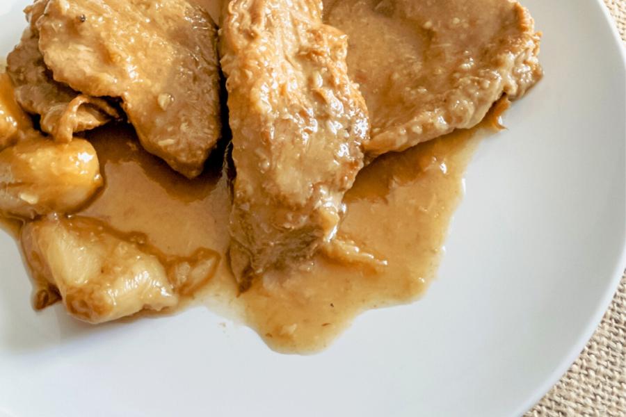A plate of pork tenderloin in a wine sauce.