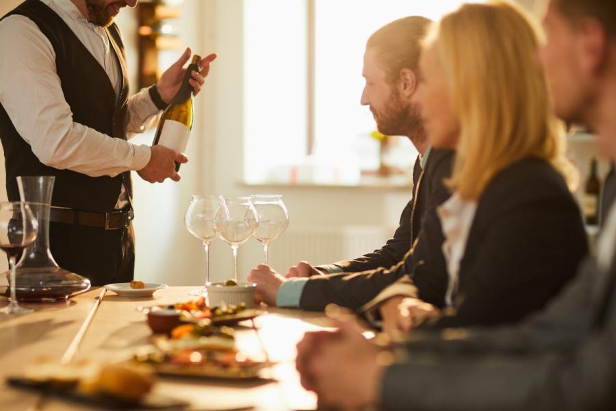 A sommelier presenting wine to a group of people during a wine tour.