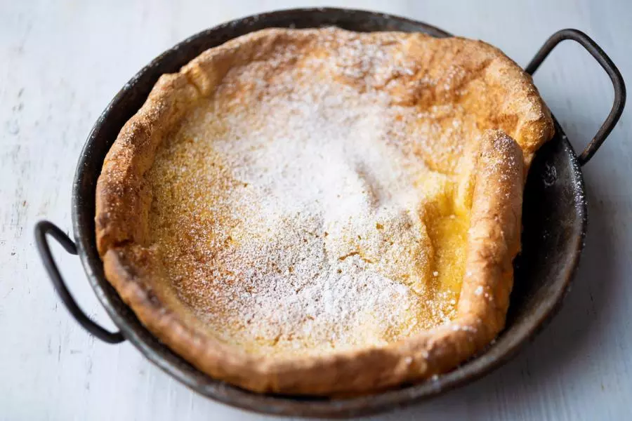 A Dutch baby pancake in a rustic pan.
