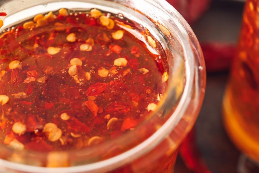 A glass jar containing homemade hot honey, not strained.