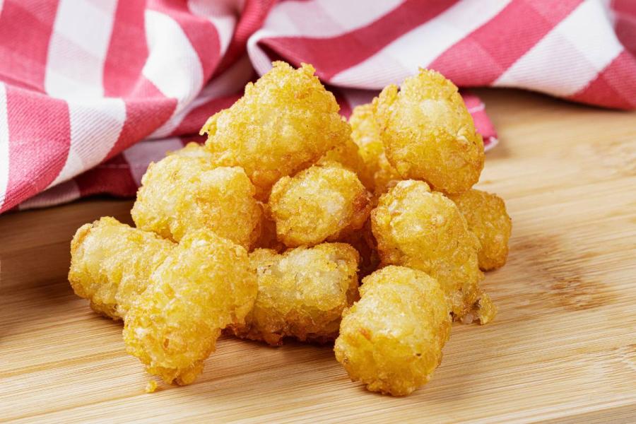 Tater tots on a wooden surface.