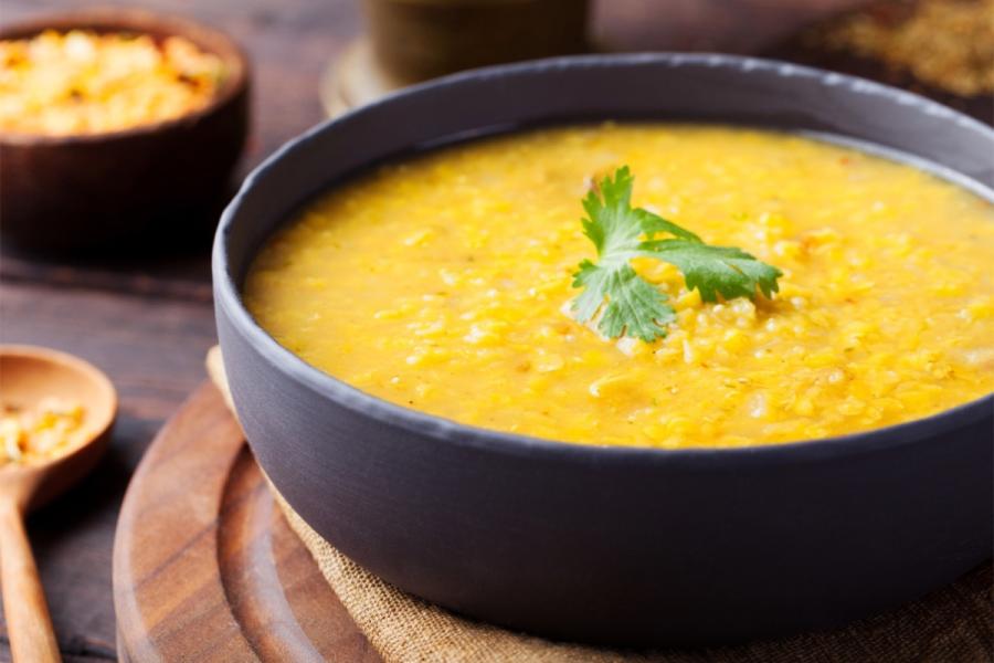 A bowl of smooth red lentil soup with cumin and preserved lemon.