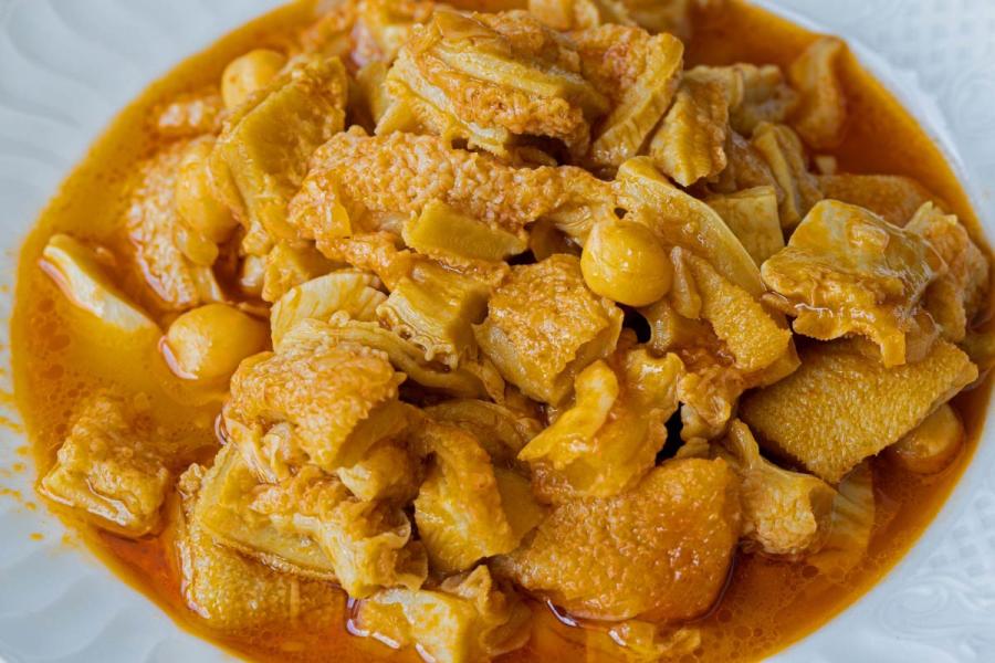 Bowl of lamb tripe stewed with chickpeas in a reddish tomato and paprika broth