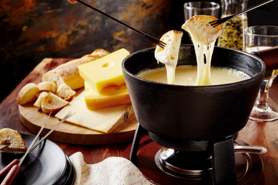 Swiss cheese fondue in a caquelon, with bread on the side.
