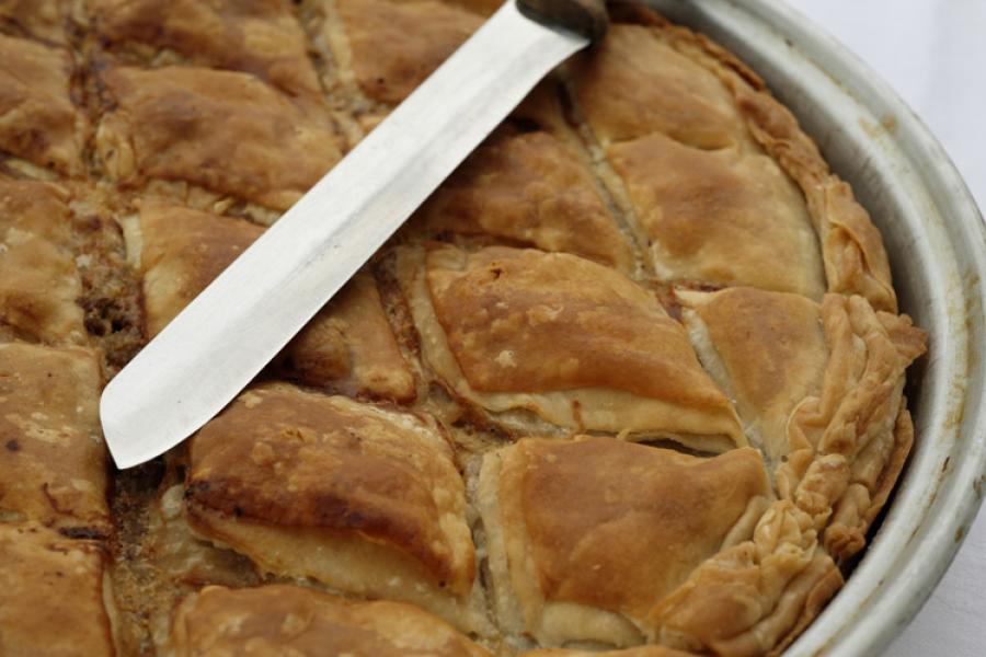 Greek meat pie with a knife.