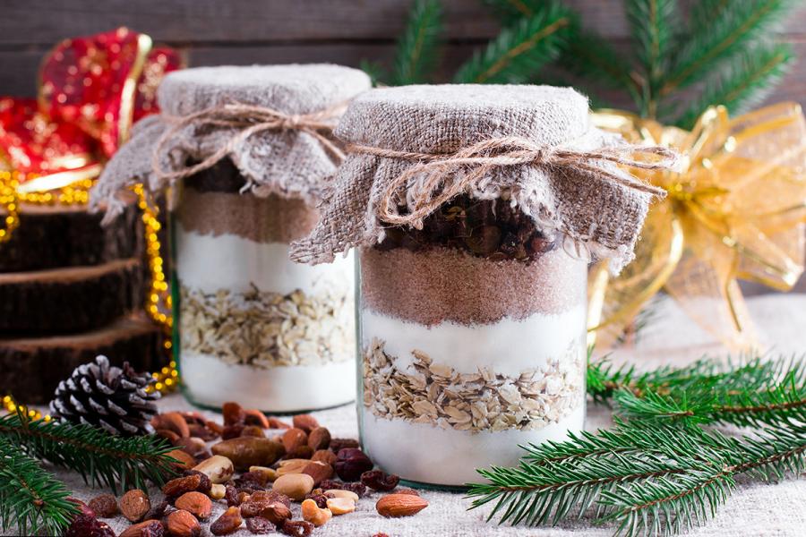 Two gift jars with chocolate chip cookie mix on a Christmas setting.