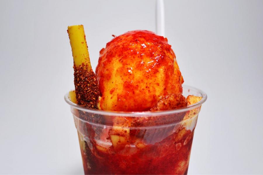 Mangonada with chamoy sauce and chili powder in a cup.